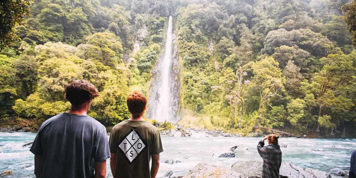 Group In New Zealand Near Waterfall