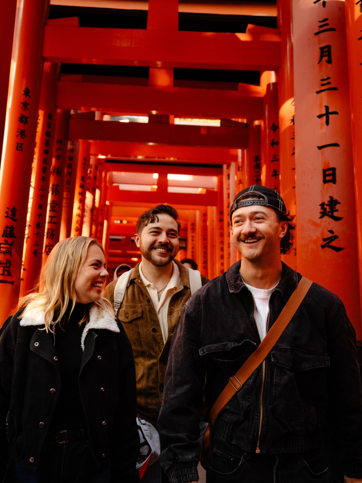 Travellers walking through the red torii gates at Fushimi Inari Shrine in Kyoto, Japan.