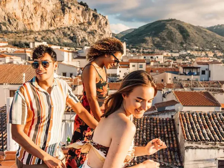 Trio Of Young Travelers On Rooftops In Sicily