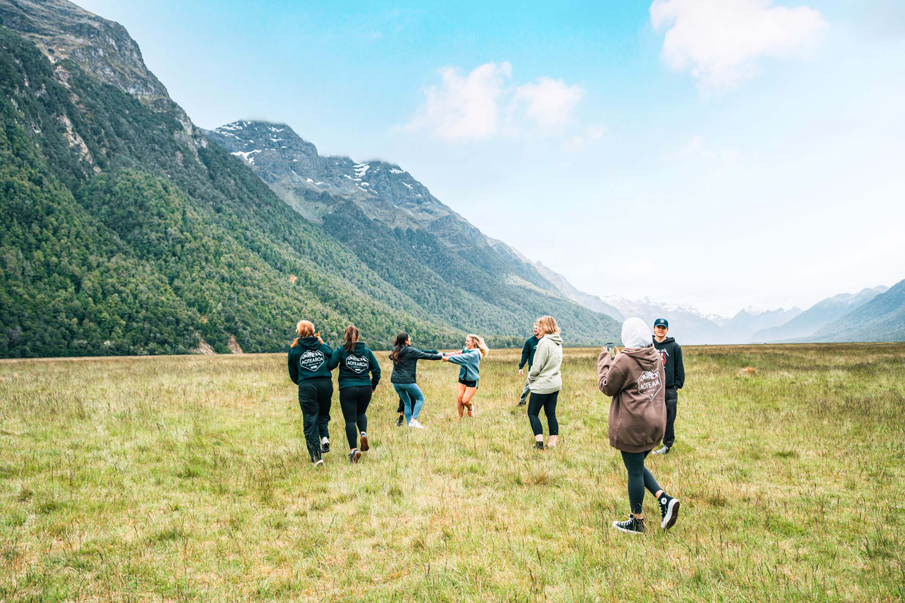 group-of-people-enjoying-a-mountain-landscape-green-grass.jpg