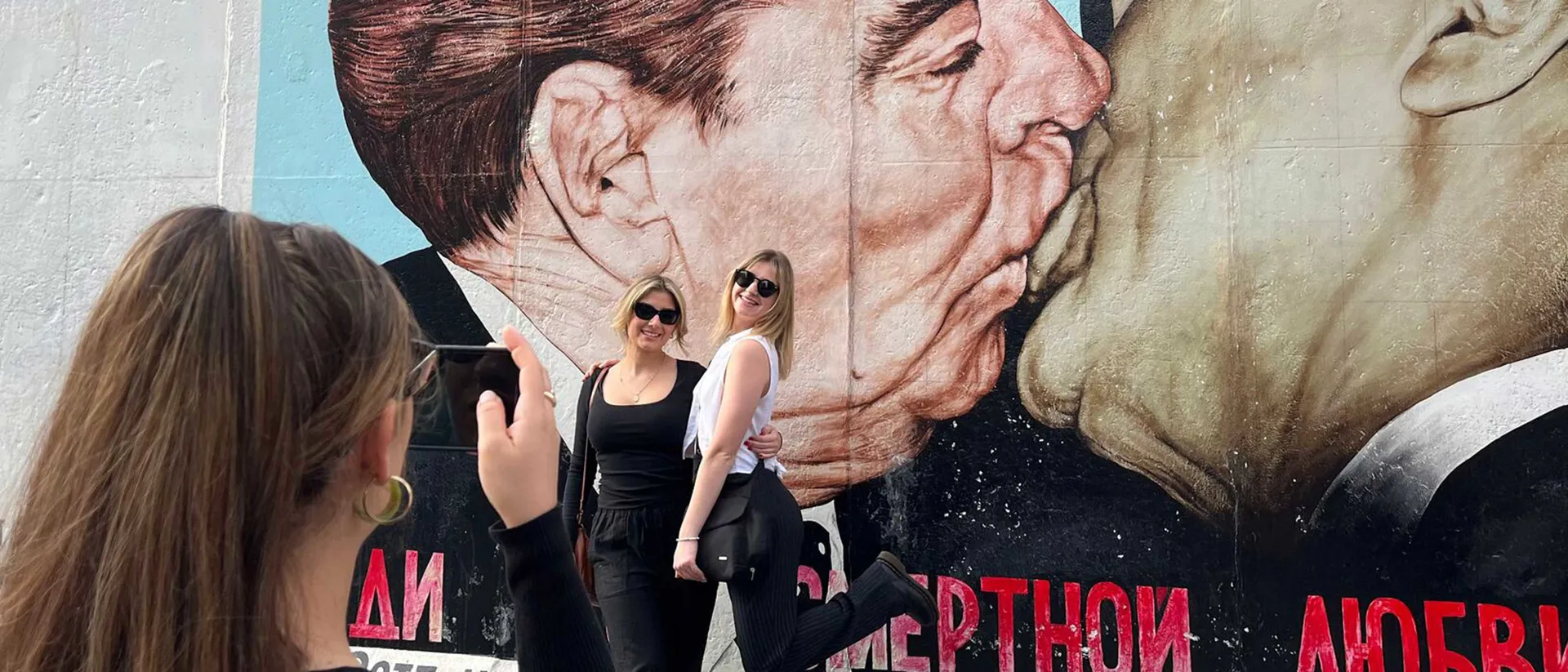Travellers in front of East Side Gallery mural, Berlin, Germany Travellers in front of East Side Gallery mural, Berlin, Germany
