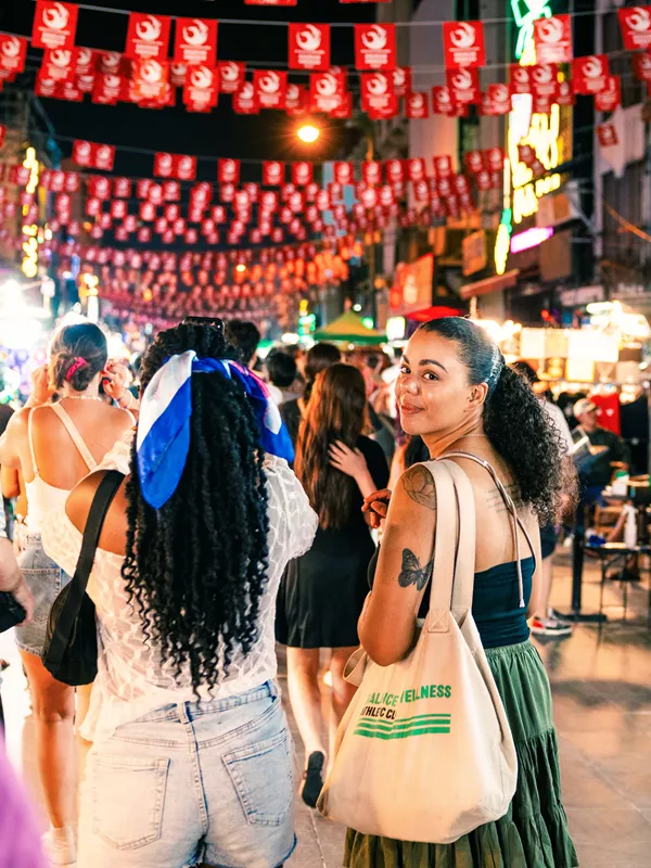 Traveller walking on Khao San road, looking back at camera, Bangkok, Thailand