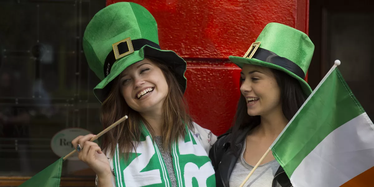 Two Girls Wearing Irish Hats Holding Irish Flags