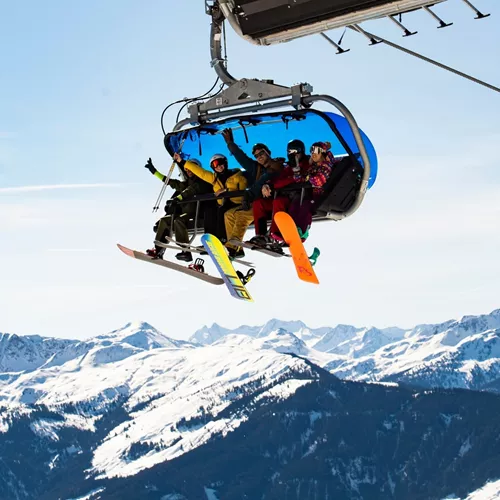 Travellers riding a chairlift with panoramic views of the Austrian Alps on the Contiki Ski Austria 35 to 45 Tour