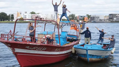 A group of people standing on top of a boat