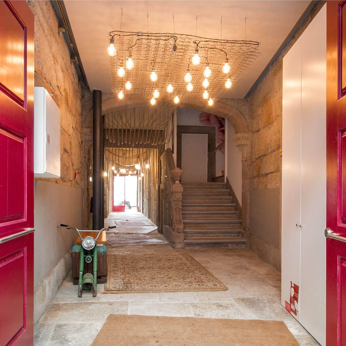 Corridor with stairs and a chandelier