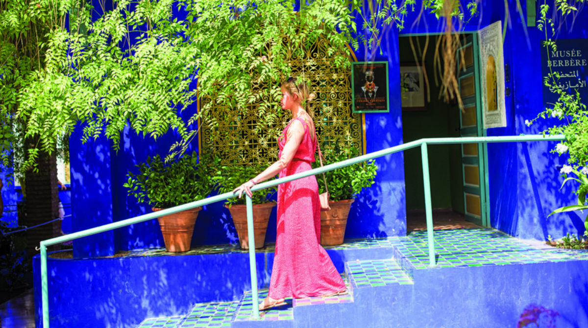 Woman Walking Downstairs Blue Walls Green Plants Around