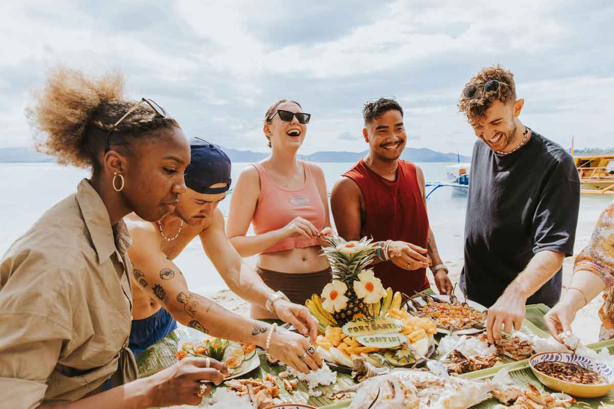 Young friends enjoying food at the beach in the Philippines.