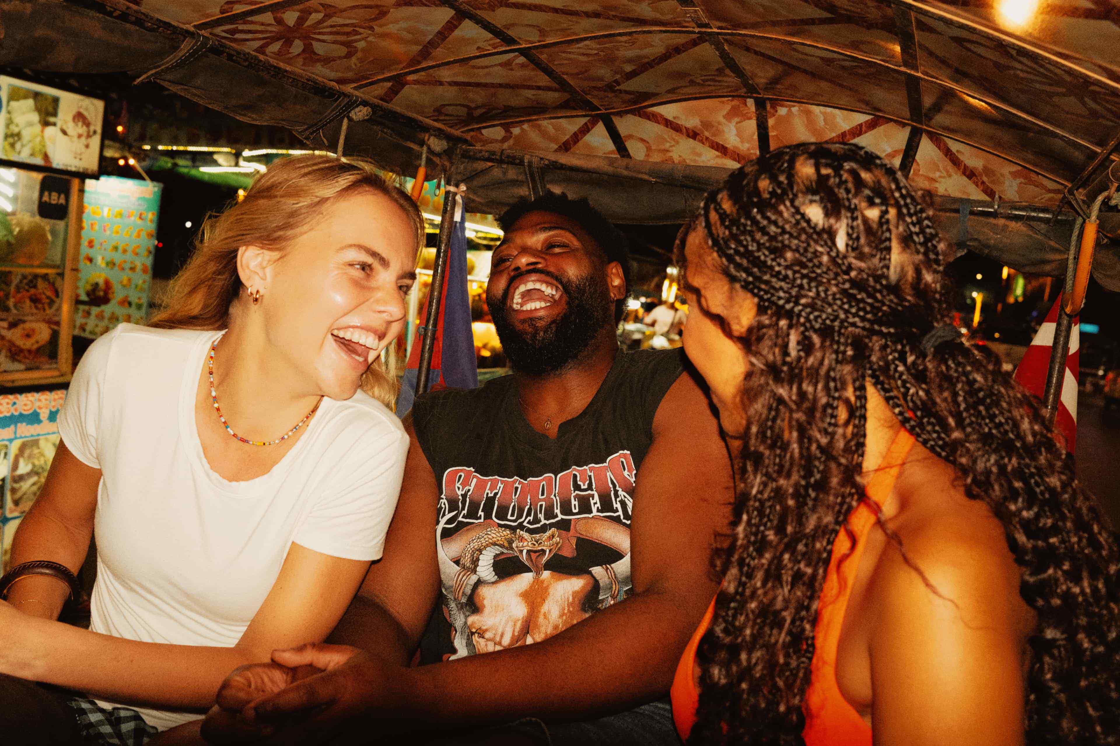 travellers-laughing-together-while-riding-a-tuk-tuk-through-a-night-market-in-cambodia.jpg