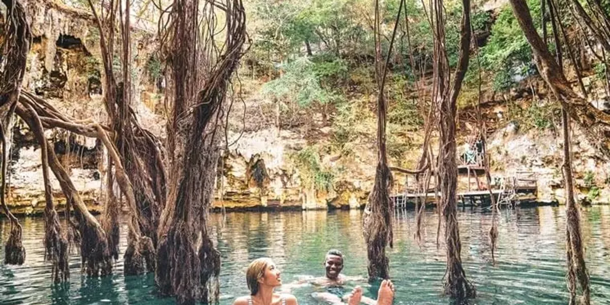 A Couple Swimming in the Water Surrounded by Rocks and Plants