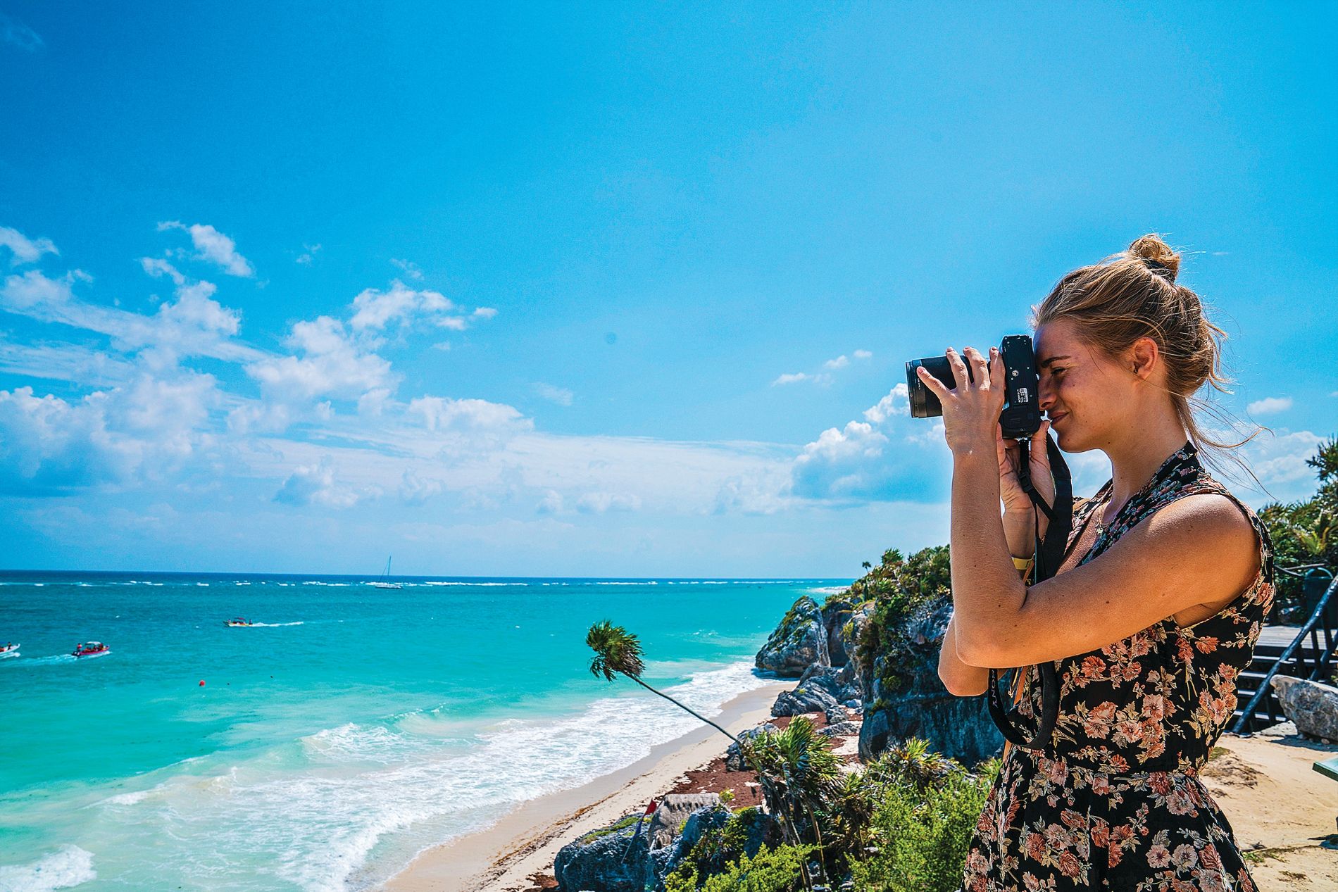 Woman in dress taking a photo on beach in Cartagena, Colombia