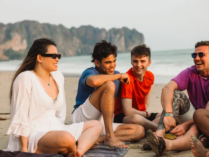 Group Sat On Beach In Thailand
