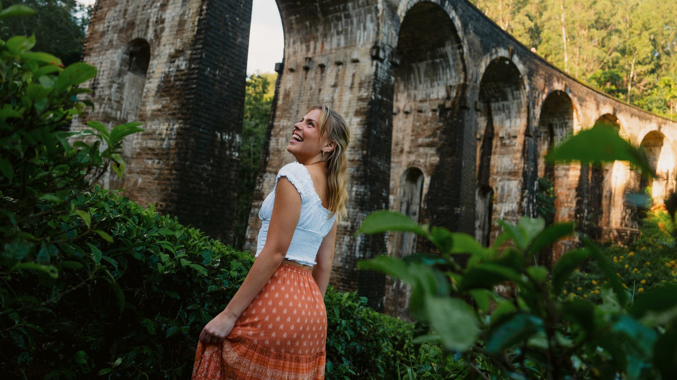 Female admiring the Nine Arch Bridge surrounded by lush forest in Ella, Sri Lanka - Contiki Best of Sri Lanka Tour