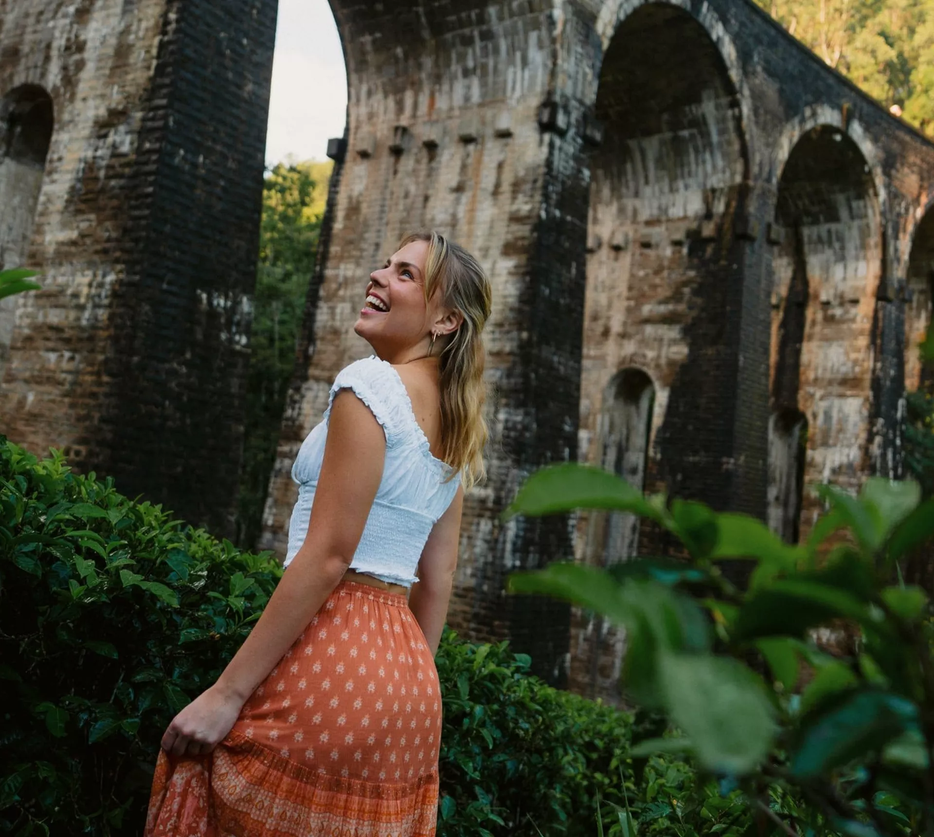 Female admiring the Nine Arch Bridge surrounded by lush forest in Ella, Sri Lanka - Contiki Best of Sri Lanka Tour