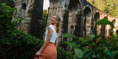 Female admiring the Nine Arch Bridge surrounded by lush forest in Ella, Sri Lanka - Contiki Best of Sri Lanka Tour