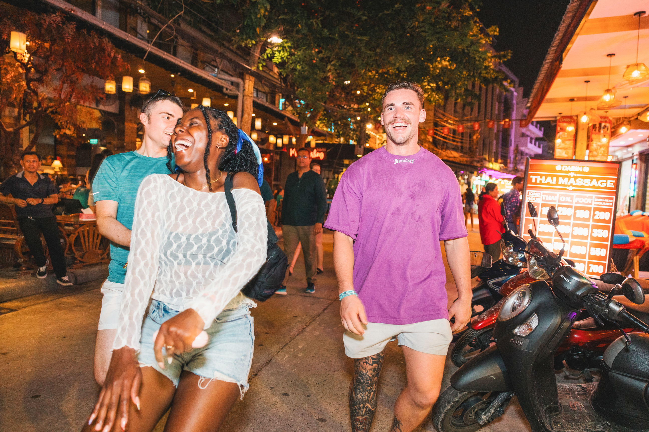 Travellers walking and laughing on Khao San road, Bangkok, Thailand