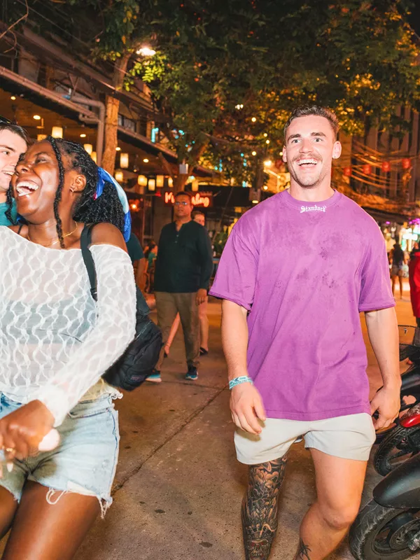 Travellers walking and laughing on Khao San road, Bangkok, Thailand