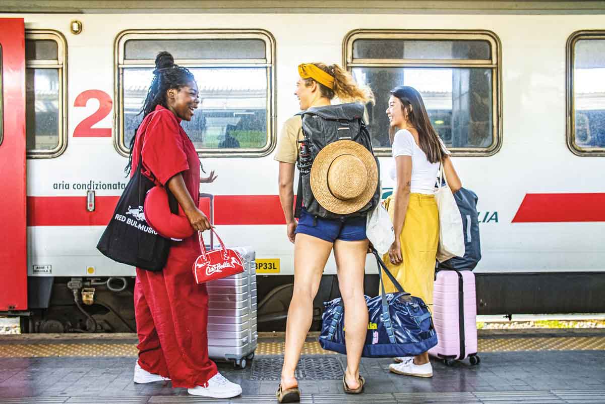 Female Travelers Laughing On Train Platform 