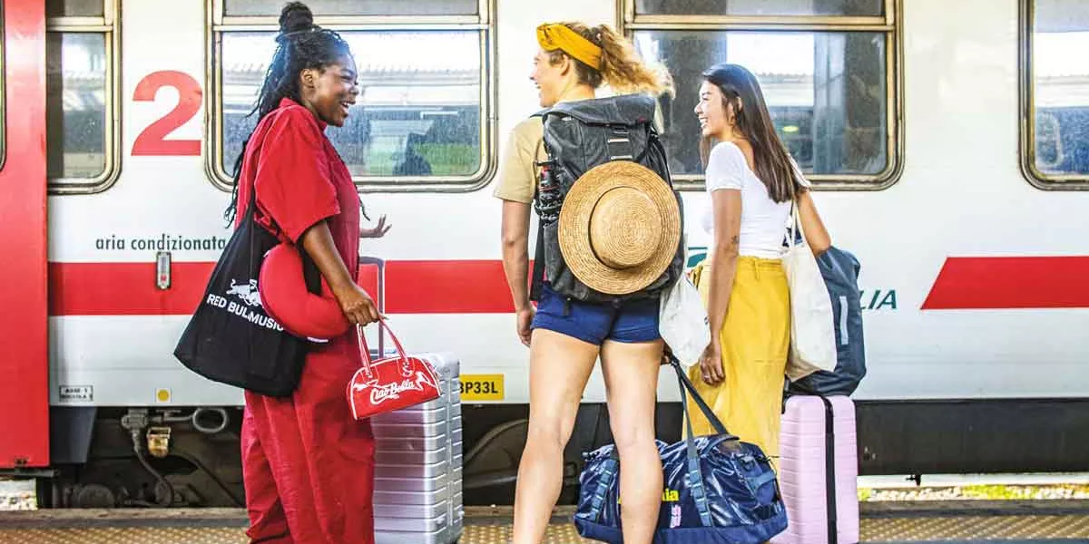 Female Travelers Laughing On Train Platform