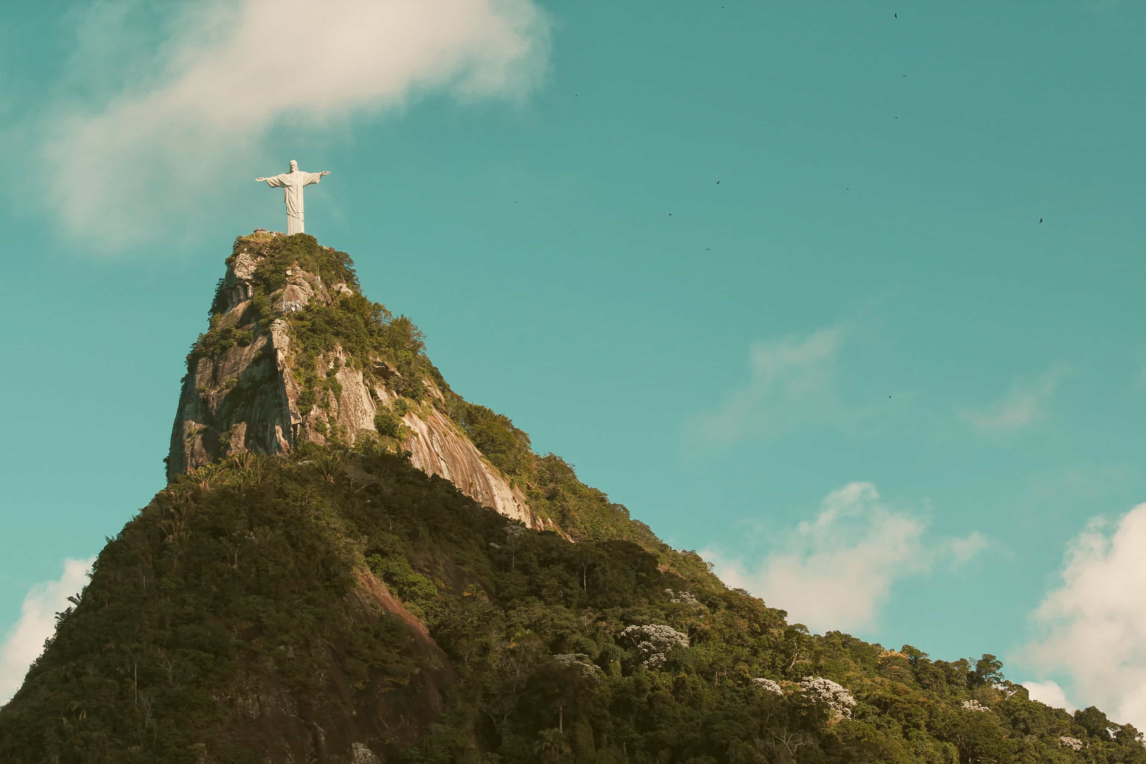 Christ the Redeemer statue crowning the forested peak of Corcovado mountain in Rio de Janeiro, Brazil.