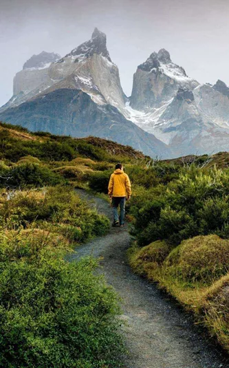 Traveller hiking through Patagonia with dramatic mountain peaks on the Contiki Active Patagonia Tour
