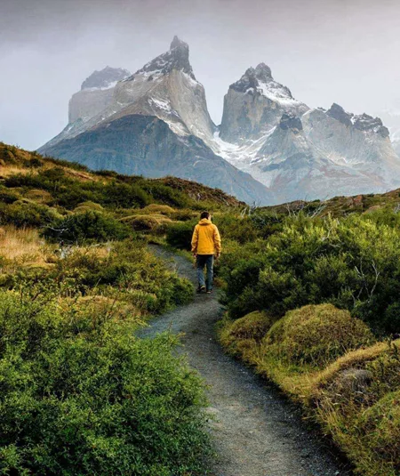 Traveller hiking through Patagonia with dramatic mountain peaks on the Contiki Active Patagonia Tour