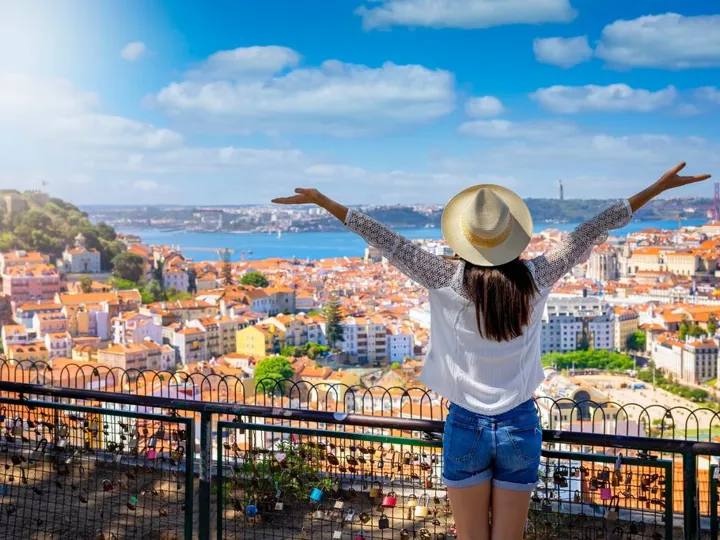a-happy-tourist-woman-overlooks-the-colorful-old-town-alfama-of-lisbon-city.jpg