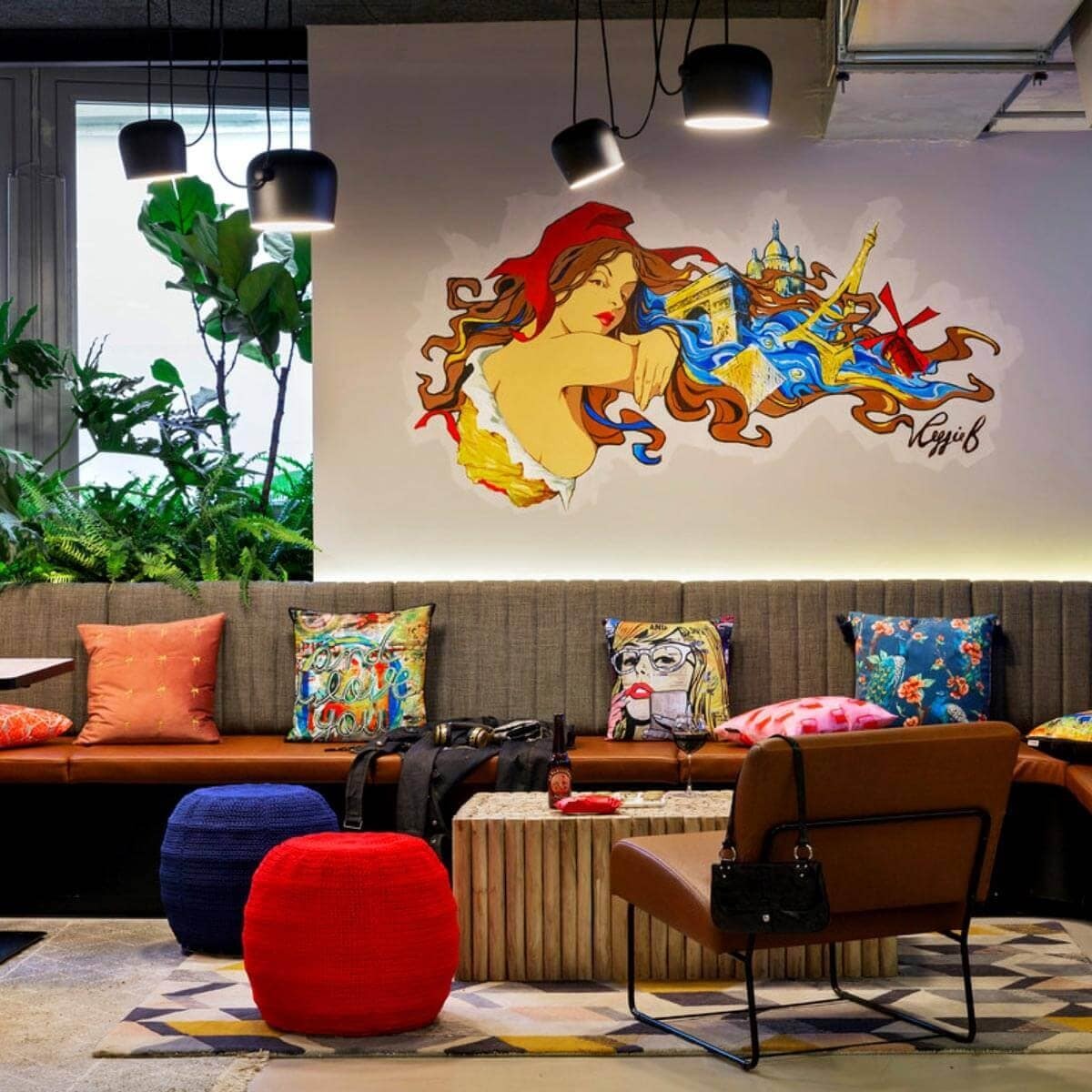 Moxy Paris Bastille lounge with couch, armchair and mural on the wall