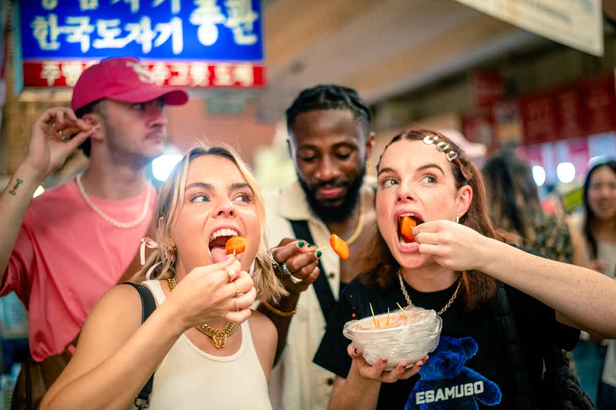 Group Of Young Travelers Eating Street Food in South Korea