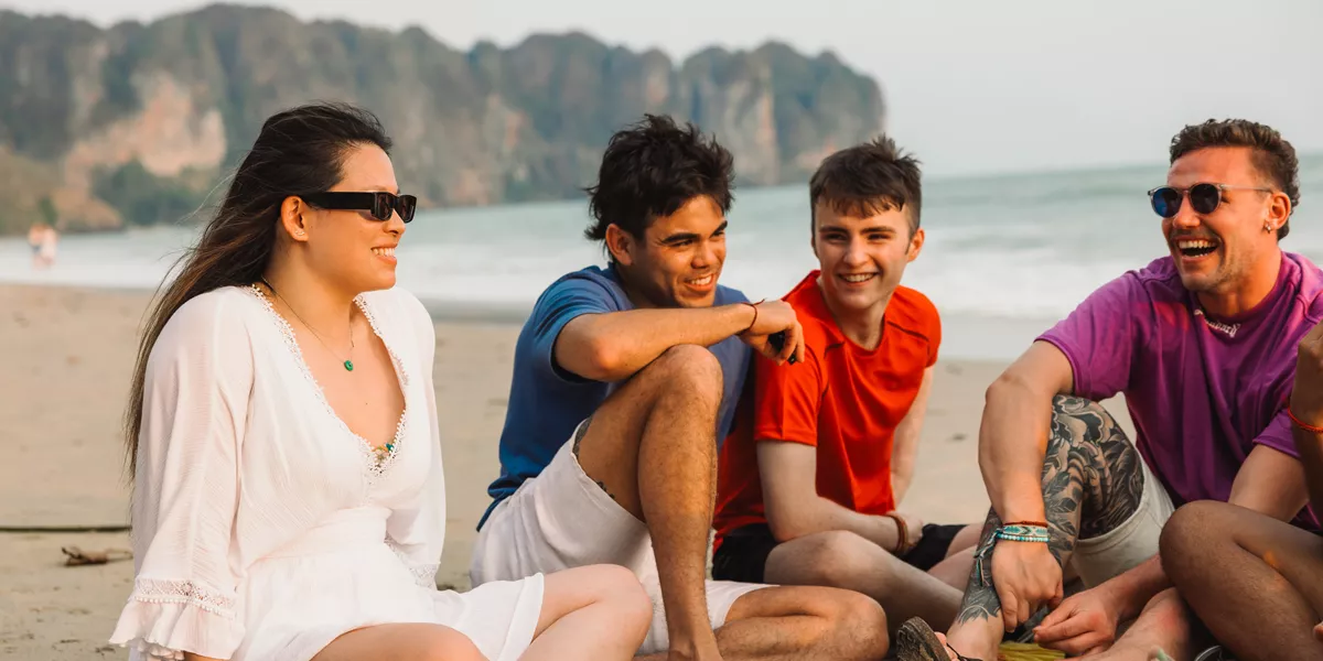 Group Sat On Beach In Thailand