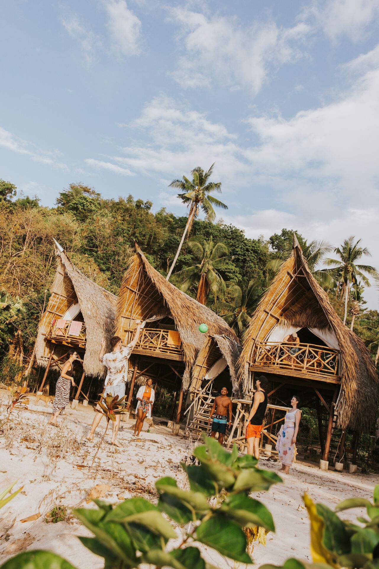 Group of people playing with ball outside of Isla huts