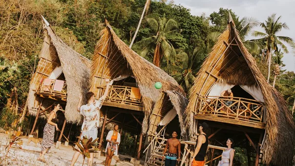 Group of people playing with ball outside of Isla huts