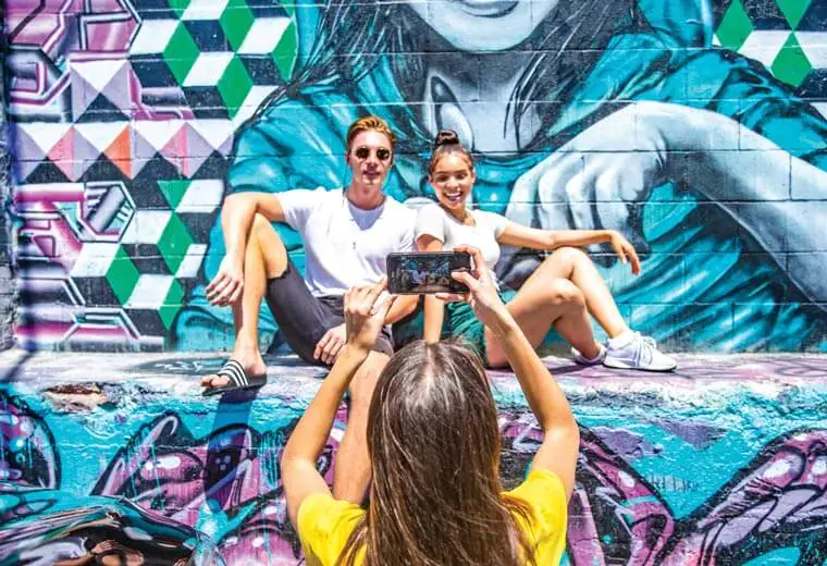 Couple Having Photo Taken next to Graffiti Wall