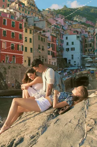 Three people relaxing by the sea in Riomaggiore, Cinque Terre - Contiki Tuscany, Milan & Venice Tour