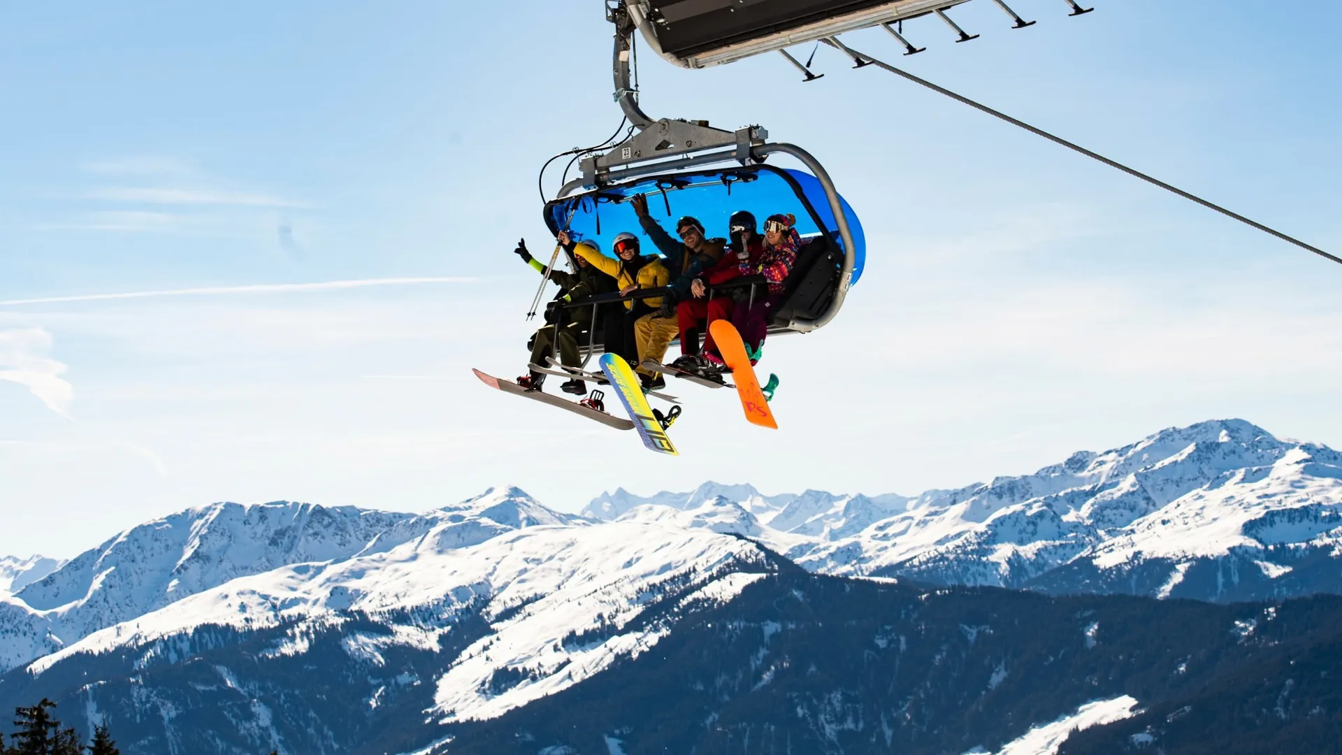 Travellers riding a chairlift with panoramic views of the Austrian Alps on the Contiki Ski Austria 35 to 45 Tour