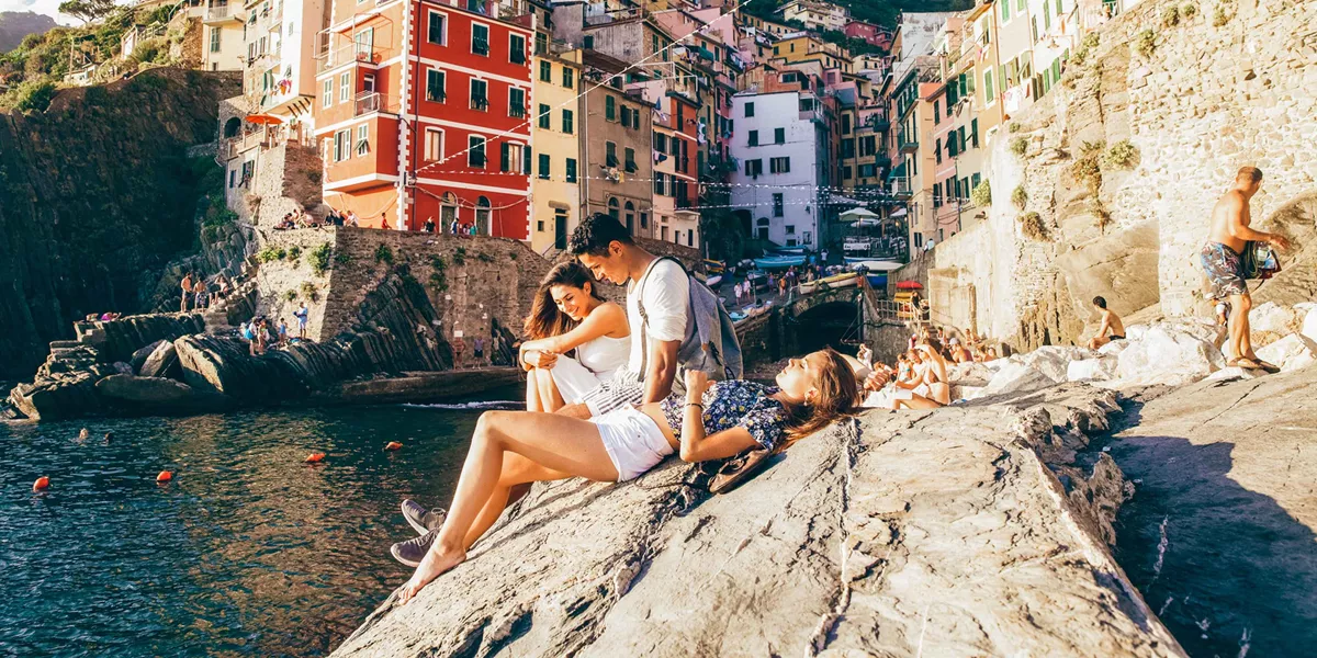 People Sat On Rocks In Italy