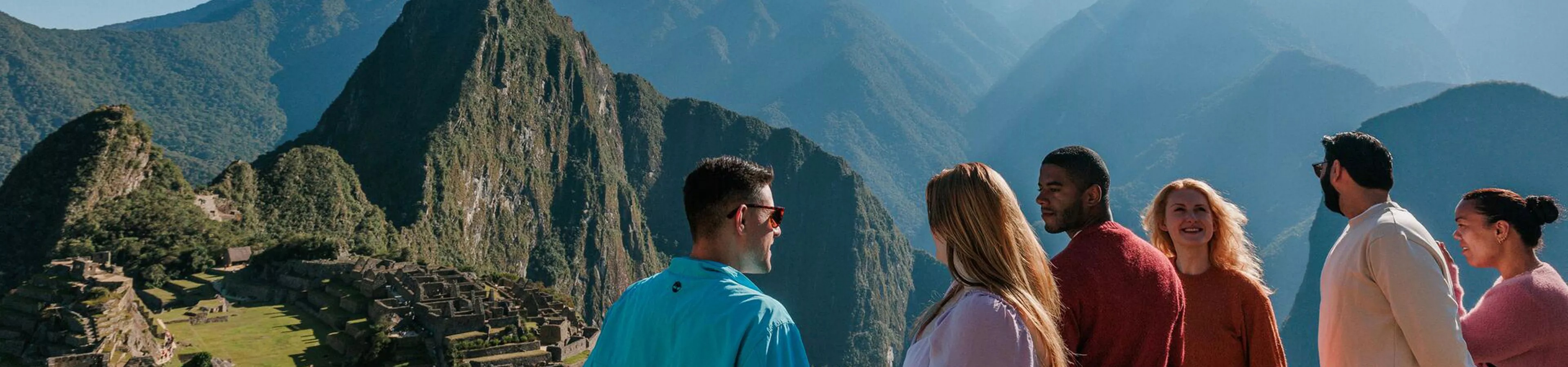 Friends smiling at each other while looking at Machu Picchu in Peru