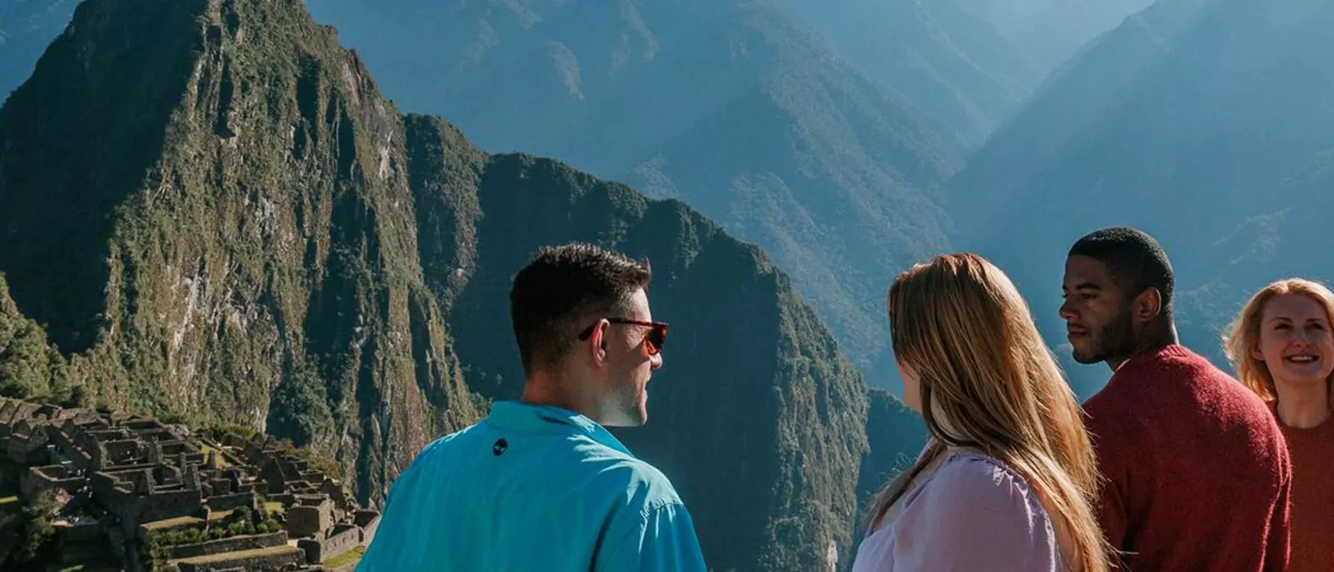 Friends smiling at each other while looking at Machu Picchu in Peru