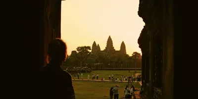 Traveller watches sunrise over Angkor Wat in Siem Reap, Cambodia, on the Contiki Cambodia & Laos Uncovered Tour, discovering one of Southeast Asia's most iconic ancient temples
