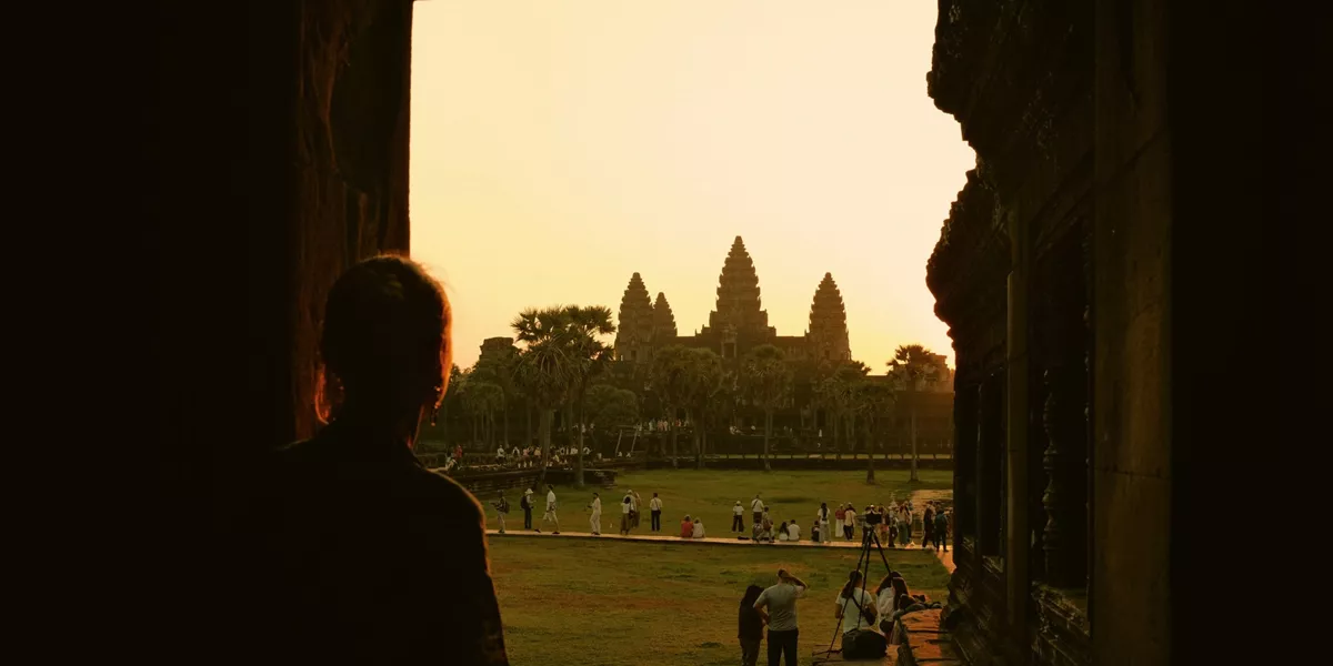 Traveller watches sunrise over Angkor Wat in Siem Reap, Cambodia, on the Contiki Cambodia & Laos Uncovered Tour, discovering one of Southeast Asia's most iconic ancient temples