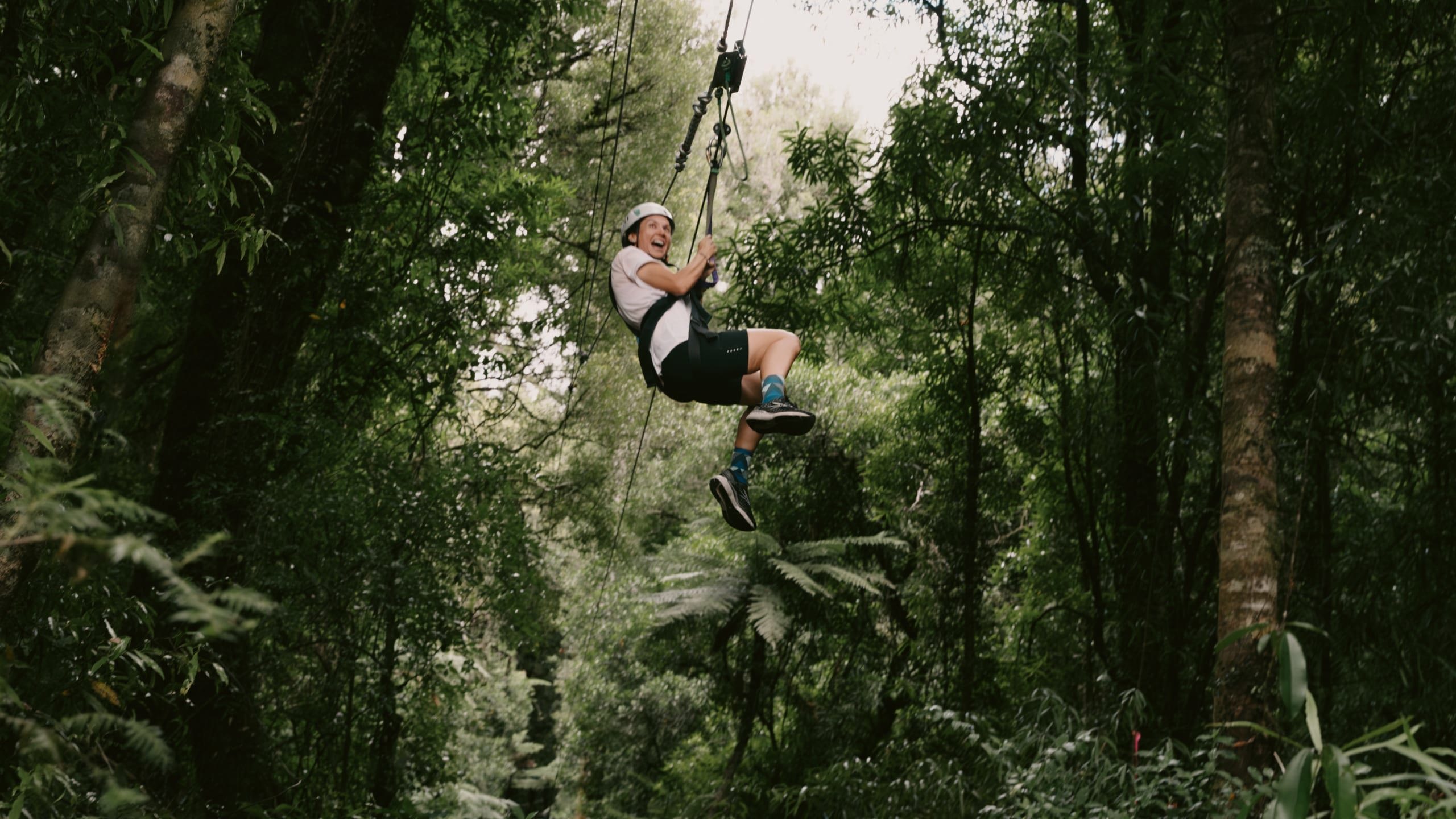 Traveller ziplining through native forest in New Zealand - Contiki North Island & Kaikōura Tour 