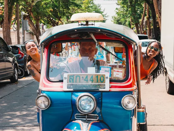 Two Friends Enjoying A Drive Ride In A Tuktuk