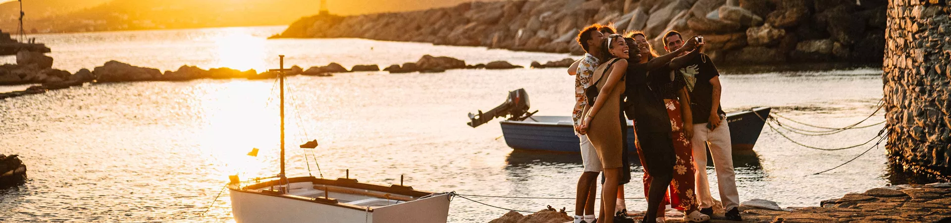 Group Of Young Travelers Taking Selfie At Sunset In Greece