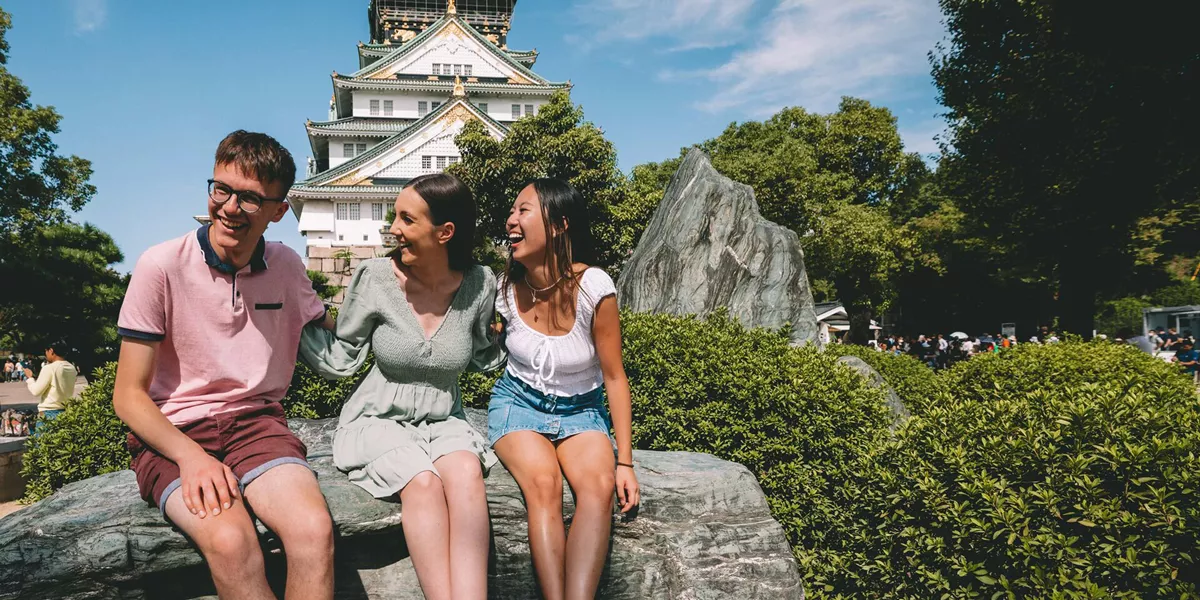 Contikijapan23 Caitmiers 0Y6A9217 Friends Smiling Osaka Landmark As Background