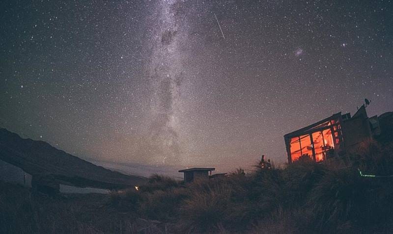Starry sky at night and a tiny hut