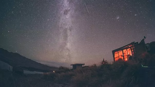 Starry sky at night and a tiny hut