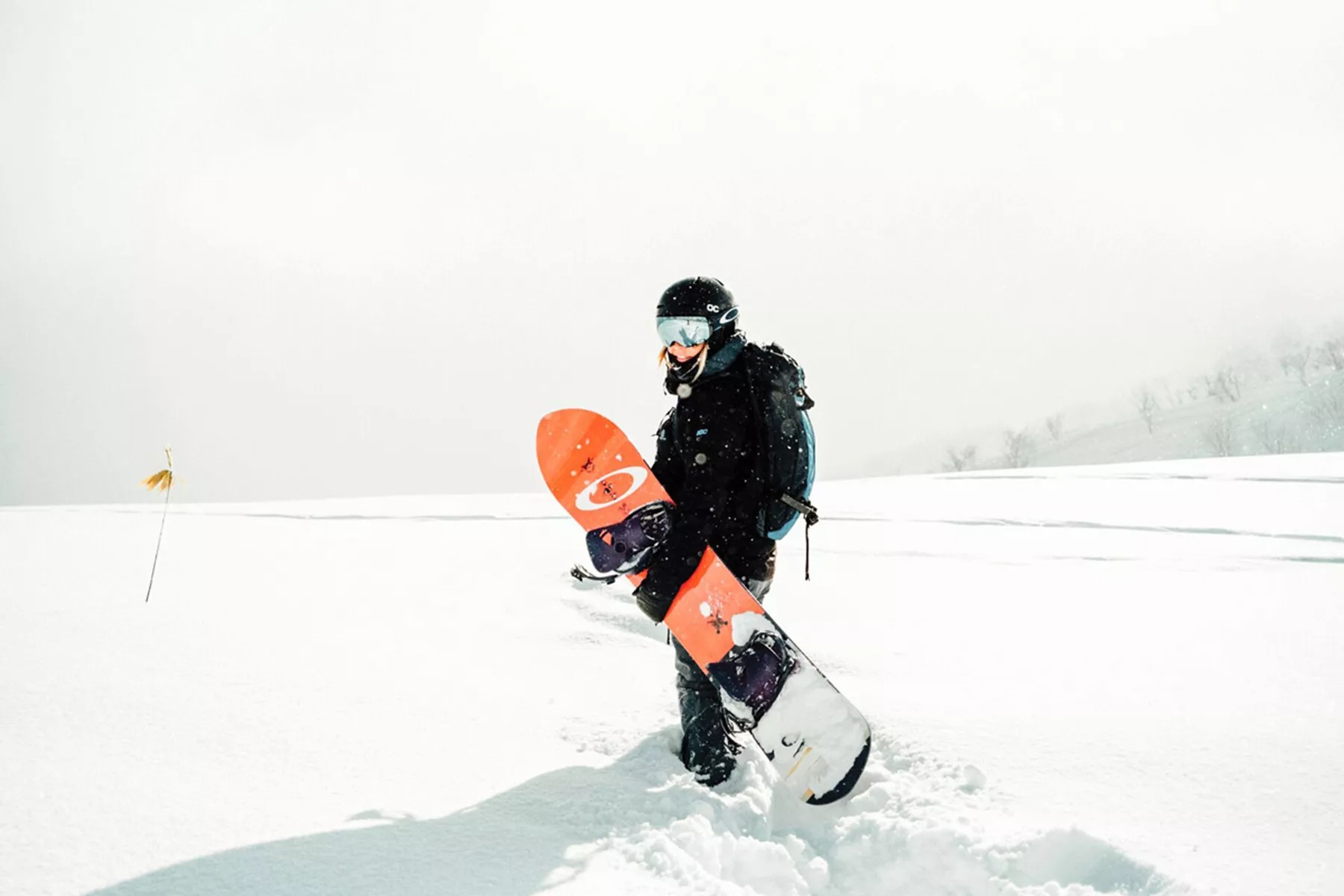 Woman in deep snow with snowboard.