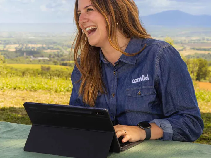 contiki-team-member-smiling-with-laptop.jpg