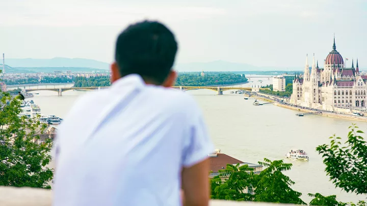Traveller at a viewpoint looking over the House of Parliament in Budapest, Hungary