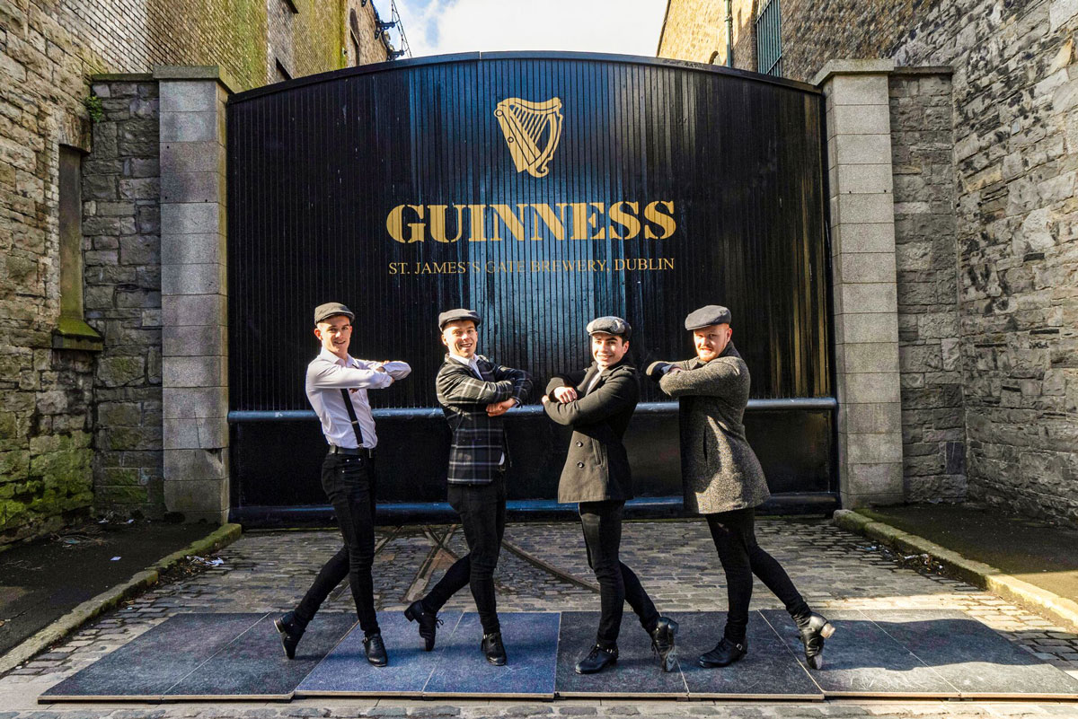 Four People Standing In Front Of Guinness Brewery Big Gate in Ireland.